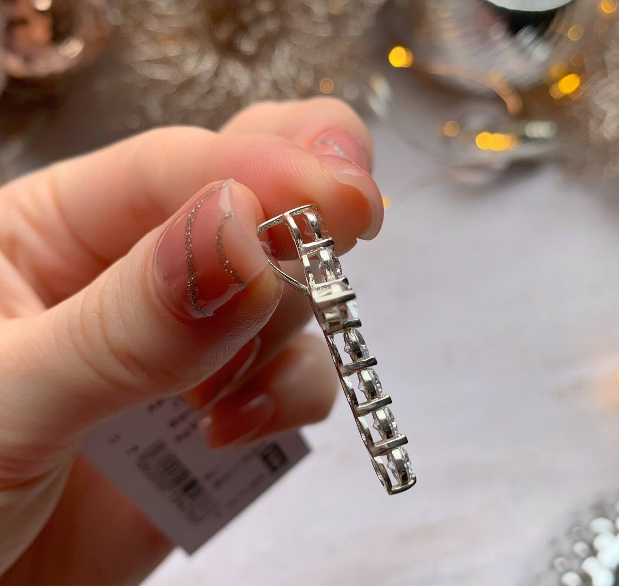 Rhodium-plated silver cross pendant with a row of sparkling cubic zirconia