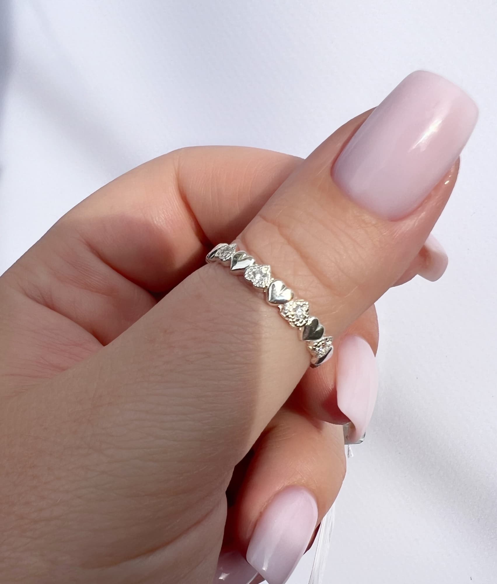 Rhodium-plated silver ring with a row of hearts and stones