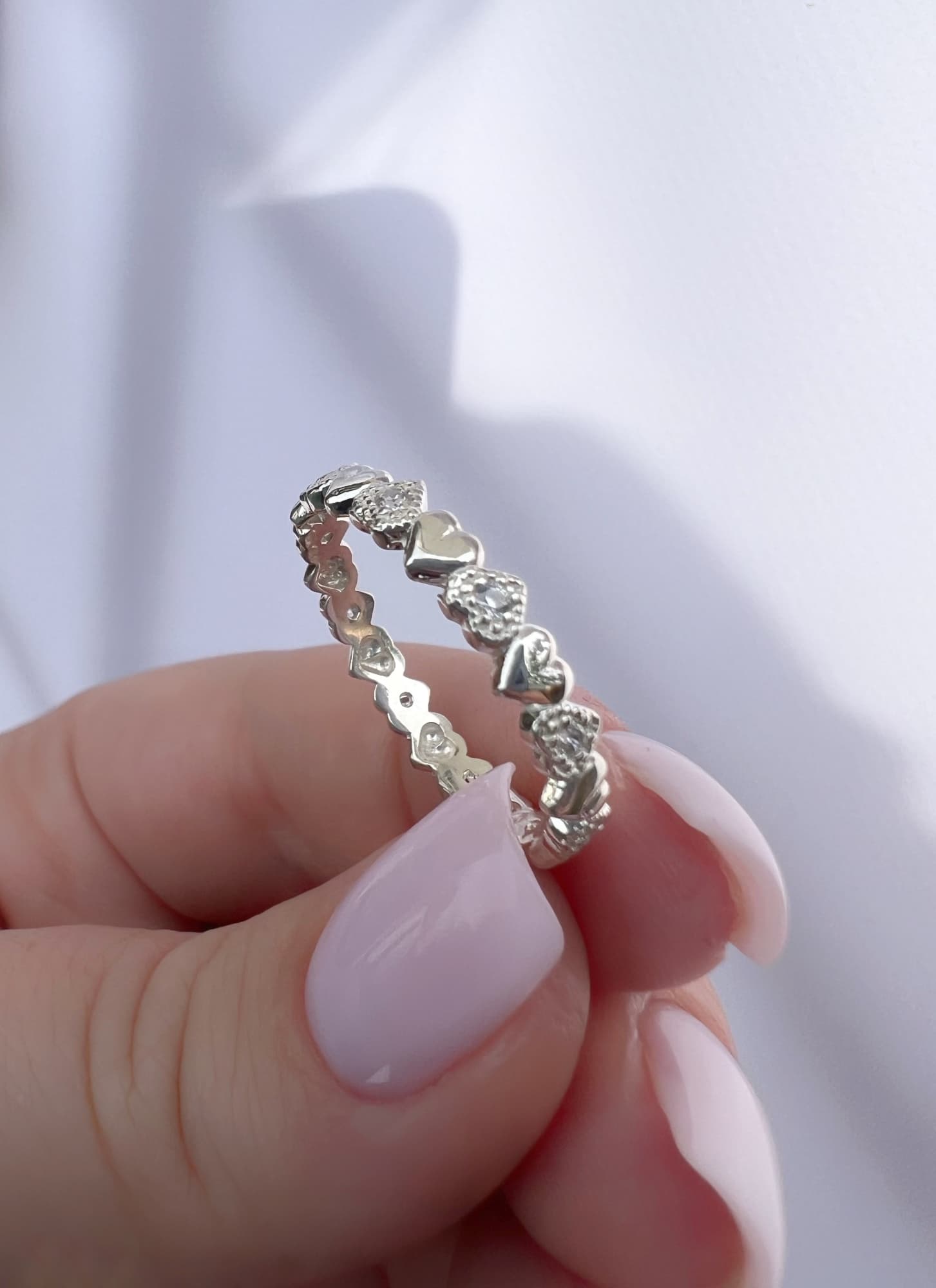 Rhodium-plated silver ring with a row of hearts and stones