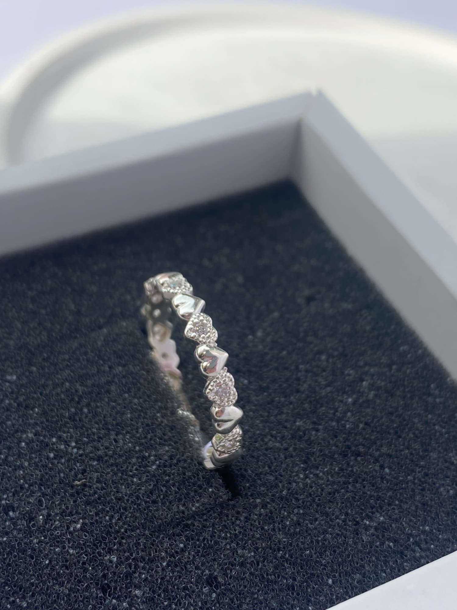Rhodium-plated silver ring with a row of hearts and stones