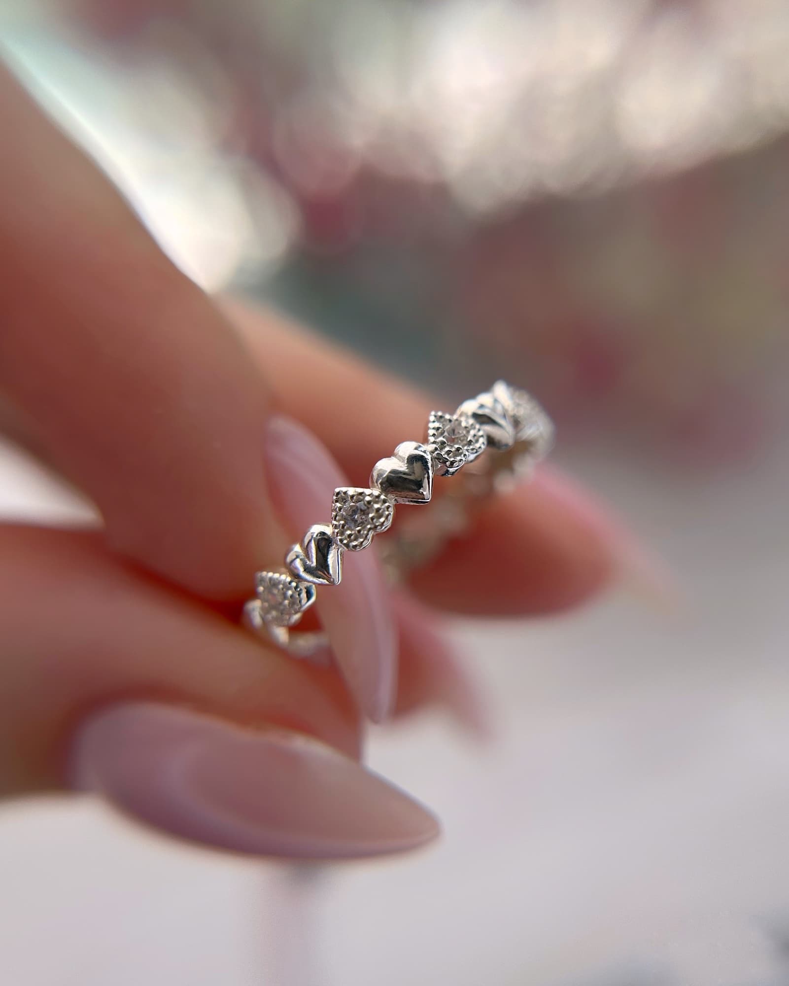 Rhodium-plated silver ring with a row of hearts and stones