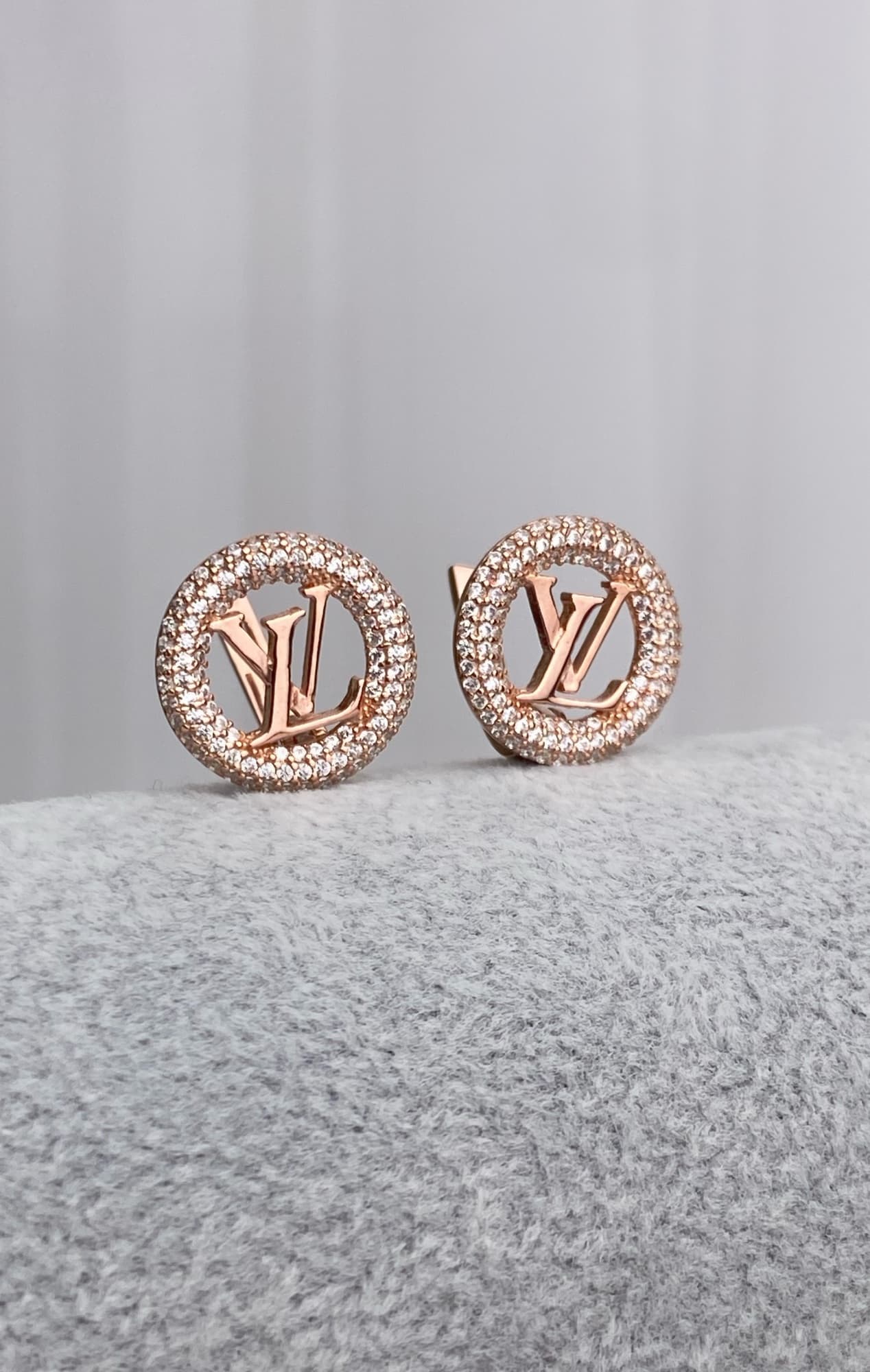 Silver earrings with a logo in a round stone-set frame
