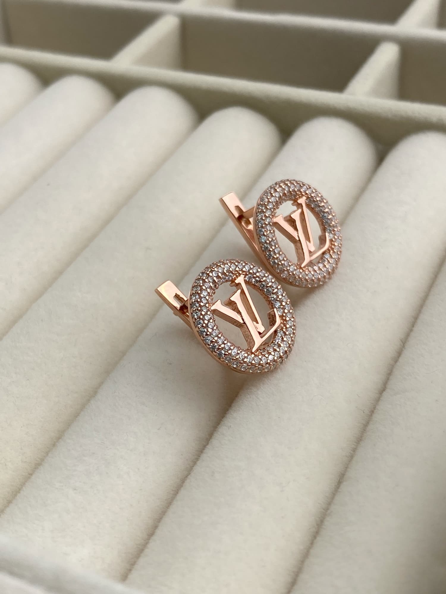 Silver earrings with a logo in a round stone-set frame