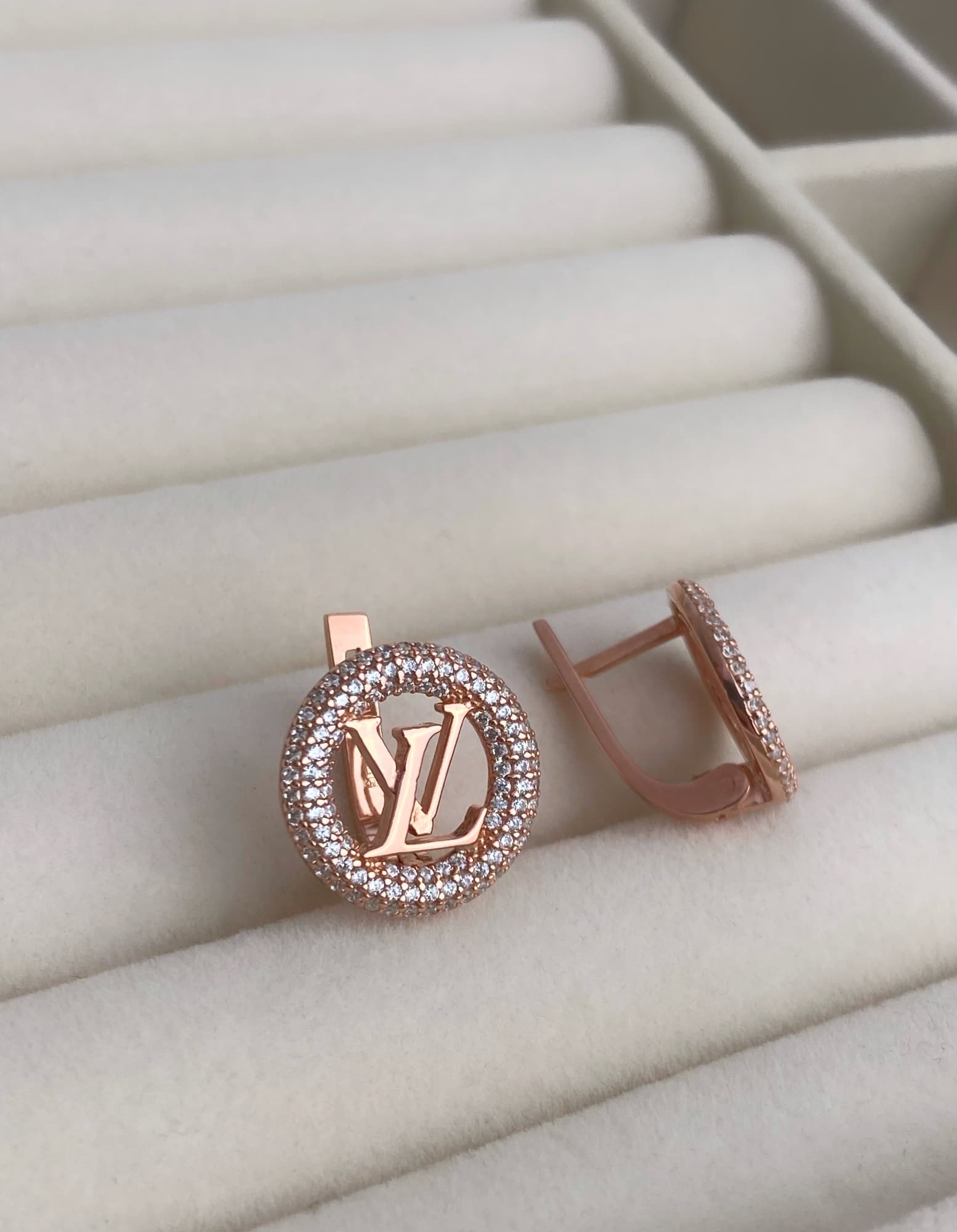 Silver earrings with a logo in a round stone-set frame