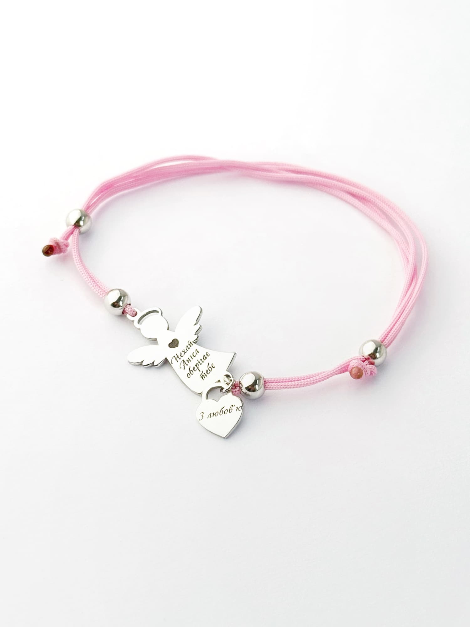 Silver angel bracelet with a heart on a pink cord