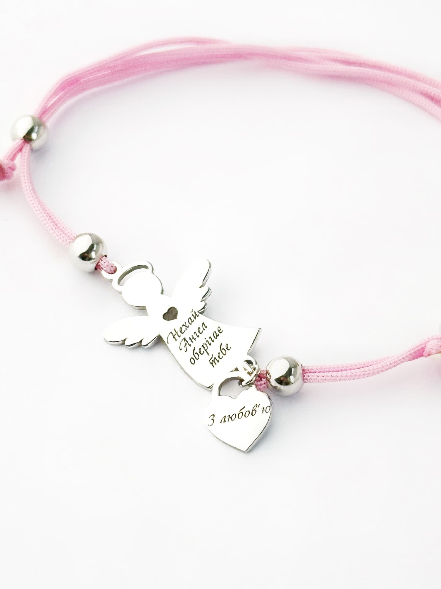 Silver angel bracelet with a heart on a pink cord